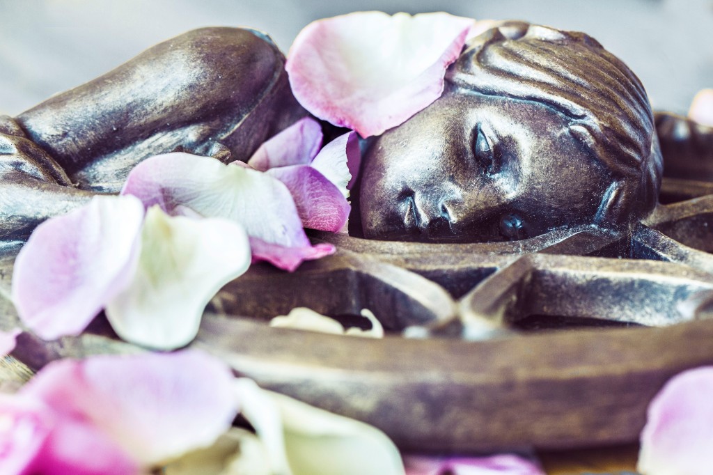 Image of a Goddess statue lying on a pentagram with flower petals scattered around her. Goddess must Rest image credit NEJ Photography based in Hereford and the local area featured at SpookyMrsGreen.com mindful parenting and modern pagan lifestyle blog.