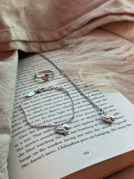 Image of a heart pendant necklace, bracelet and ring sitting on the pages of an open book. Jewellery Obsession Expressive Jewellery Pieces, crystal jewellery, affordable jewellery gifts affiliated with SpookyMrsGreen.com mindful parenting and modern pagan lifestyle blog.