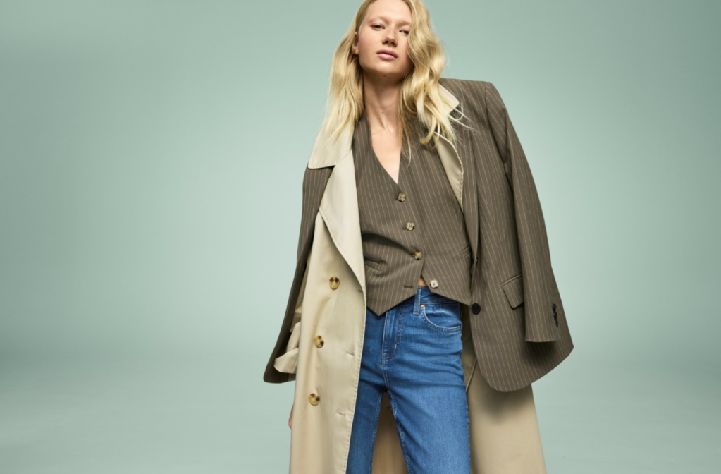 Image of a female model wearing jeans with a pinstripe waistcoat, pinstripe jacket and beige overcoat. M&S Spring fashion collection affiliated with SpookyMrsGreen.com mindful parenting and modern pagan lifestyle blog.